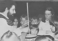 Traveling instrument maker Tony Pizzo demonstrates a playing technique to his students